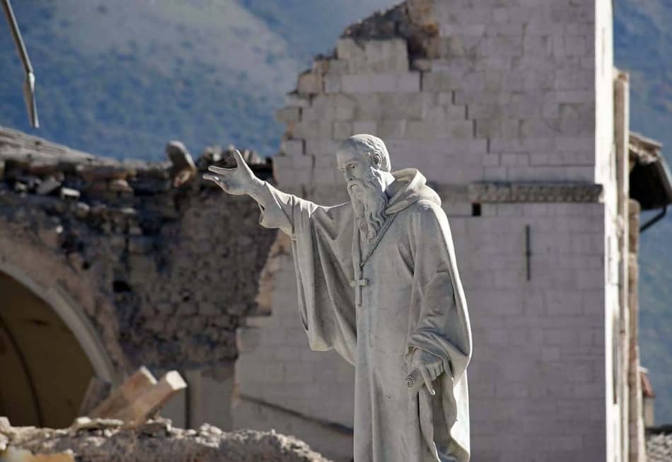 San Benedetto è rimasto davanti alla sua chiesa sfondata, la regola benedettina del “prega e lavora”